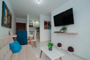 uma sala de estar com um sofá e uma televisão de ecrã plano em Apartamento El Colibri Cartagena en torre PRIMI em Cartagena das Índias