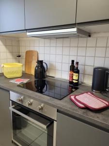 a kitchen with a stove and two bottles of wine at ALA Living Stadt-Schwärmer Apartment 10min zum Ulmer Münster & Ulmer Altstadt, WLAN & Arbeitsplatz in Neu Ulm