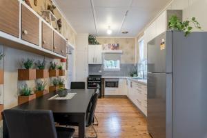 a kitchen with a table and a refrigerator at Cozy Private Single Room in Carramar - Nearby Station & Shops - Shared Bathroom in Sydney