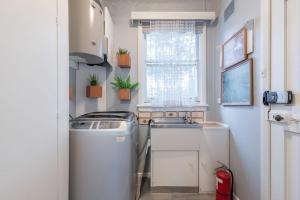 a kitchen with a washing machine and a window at Cozy Private Single Room in Carramar - Nearby Station & Shops - Shared Bathroom in Sydney