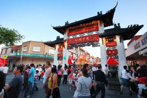 a crowd of people walking around a street with a gate at Cozy Private Single Room in Carramar - Nearby Station & Shops - Shared Bathroom in Sydney