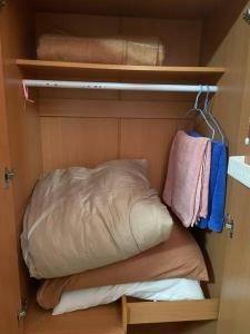 um pequeno armário com uma cama e toalhas em ห้องพักใกล้ArenaMuang ThongThani em Ban Song Hong