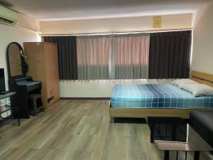 um quarto com uma cama, um sofá e um piano em ห้องพักใกล้ArenaMuang ThongThani em Ban Song Hong