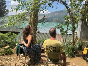 a man and woman sitting in chairs looking at a house at Pedro home stay in Nuwara Eliya