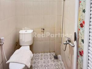 mała łazienka z toaletą i prysznicem w obiekcie Hotel Andono RedPartner near YIA w mieście Yogyakarta