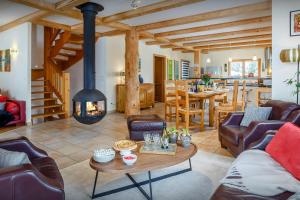 a living room with a fireplace and a table at Chalet la Croix Meridionale - OVO Network in Manigod