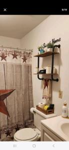 a bathroom with a toilet and a shelf on the wall at Harvest Haven in Niagara Falls