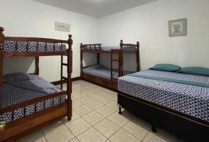 a bedroom with three bunk beds in a room at Casa 3 Salinas Monterrico completamente equipada y con piscina privada in Monterrico