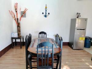 ein Esszimmer mit einem Tisch und einem Kühlschrank in der Unterkunft Casa 3 Salinas Monterrico completamente equipada y con piscina privada in Monterrico