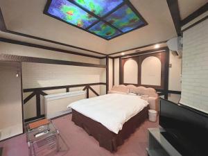 a bedroom with a large bed with a stained glass window at チョコレ新潟 in Higashi-horidōri