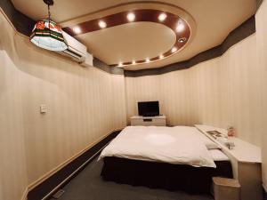 um pequeno quarto com uma cama e um espelho em チョコレ新潟 em Higashi-horidōri