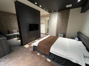 a bedroom with a large bed and a flat screen tv at チョコレ新潟 in Higashi-horidōri
