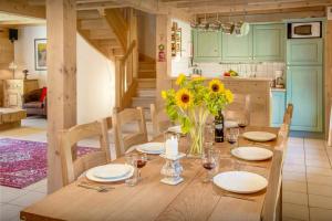 a wooden table with sunflowers in a kitchen at Chalet L'Ours Blanc - OVO Network in Le Grand-Bornand