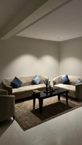 uma sala de estar com um sofá e uma mesa de centro em شقة جميله بصالة وغرفة نوم وإدخال ذاتي em Al-Kharj
