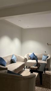 uma sala de estar com sofás e uma mesa de centro em شقة جميله بصالة وغرفة نوم وإدخال ذاتي em Al-Kharj