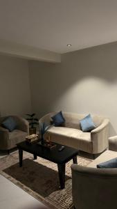 uma sala de estar com dois sofás e uma mesa de centro em شقة جميله بصالة وغرفة نوم وإدخال ذاتي em Al-Kharj