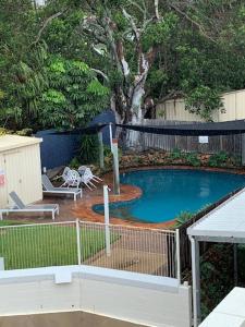 ein kleiner Pool im Hinterhof mit einem Zaun in der Unterkunft Deluxe King Studio + top floor sea views in Emu Park