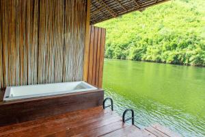 eine Badewanne auf dem Deck eines Bootes auf einem Fluss in der Unterkunft The Hub Erawan Resort in Chongsadao
