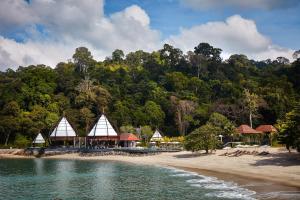 einen Strand mit einer Gruppe von Gebäuden und Bäumen in der Unterkunft The Ritz-Carlton, Langkawi in Pantai Kok