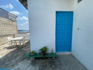 uma porta azul do lado de um edifício branco em Casa D'Andrea em Flores