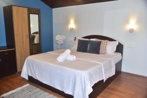 a bedroom with a large bed with towels on it at INAS OCEAN FRONT in Canacona