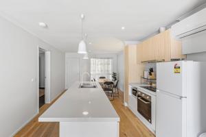 a kitchen with white appliances and a white refrigerator at Lovely Living in Lovely Banks