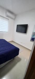 una camera con un letto blu e una finestra di Virginia III Condominium 302 a San Pedro de Macorís