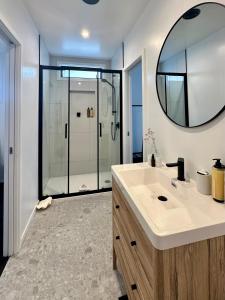 a bathroom with a sink and a mirror at Orewa Beachcomber in Orewa