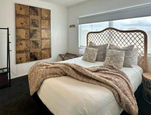 a bedroom with a bed with a blanket on it at Orewa Beachcomber in Orewa