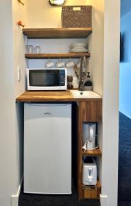 a kitchen with a counter with a microwave and a refrigerator at Orewa Beachcomber in Orewa