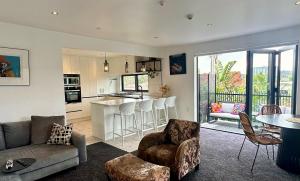 a living room with a couch and a kitchen at Orewa Beachcomber in Orewa