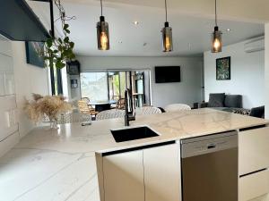 a kitchen with a counter and a living room at Orewa Beachcomber in Orewa