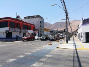 una calle de la ciudad con coches aparcados en la calle en Hotel San Felipe Iquique en Iquique