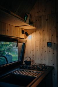 a stove top in a kitchen with wooden walls at AIVA Glamping in Partizánske