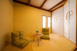 een kamer met 2 groene stoelen en een tafel bij ふくの宿 in Kamegawa +41 foto's