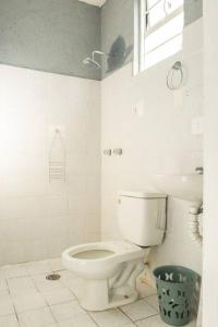 a white bathroom with a toilet and a window at Casa Jazmín (Casa familiar) in Santa Cruz Huatulco