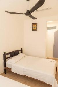 1 dormitorio con 1 cama y ventilador de techo en Casa Jazmín (Casa familiar) en Santa Cruz Huatulco