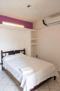 1 dormitorio con 1 cama grande con sábanas blancas en Casa Jazmín (Casa familiar) en Santa Cruz Huatulco