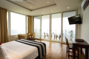 a bedroom with a bed and a desk with a television at A'Lankaa Resorts & Spa in Badulla
