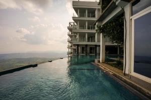 a swimming pool in front of a building with water at A'Lankaa Resorts & Spa in Badulla