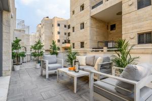 a patio with chairs and a table on a building at Unique Mini Penthouse In The Heart Of Jerusalem in Jerusalem
