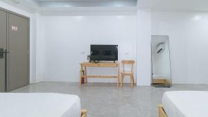 a room with two beds and a television on a table at ADC Resort and Hotel Apalit Pampanga in Apalit