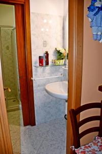 La salle de bains est pourvue d'un lavabo et d'un lavabo blanc. dans l'établissement CASA RINA, à Vintimille