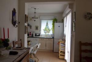 een keuken met een witte koelkast en een raam bij The Flower- Townhouse with air conditioning and garden! in Montpellier