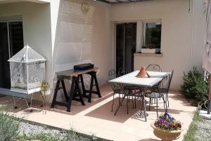 a patio with a table and chairs and a bird cage at The Flower- Townhouse with air conditioning and garden! in Montpellier