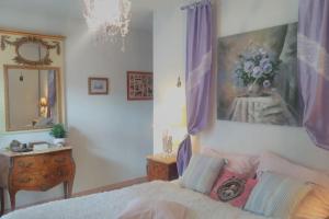 a bedroom with a bed and a painting on the wall at The Flower- Townhouse with air conditioning and garden! in Montpellier