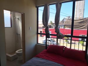 1 dormitorio con cama, ventana y aseo en Hotel San Felipe Iquique, en Iquique