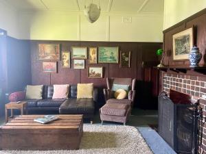 - un salon avec un canapé et une cheminée dans l'établissement The Brown House Tenterfield, à Tenterfield