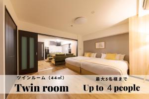 a hotel room with a bed and a living room at TAKUTO STAY SAKAISUJI-HOMMACHI in Osaka
