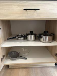 two pots and pans on a shelf in a kitchen at Studio Modern luxe apartment in Vancouver